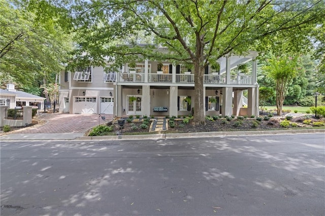 view of front facade featuring french doors, a balcony, and a garage