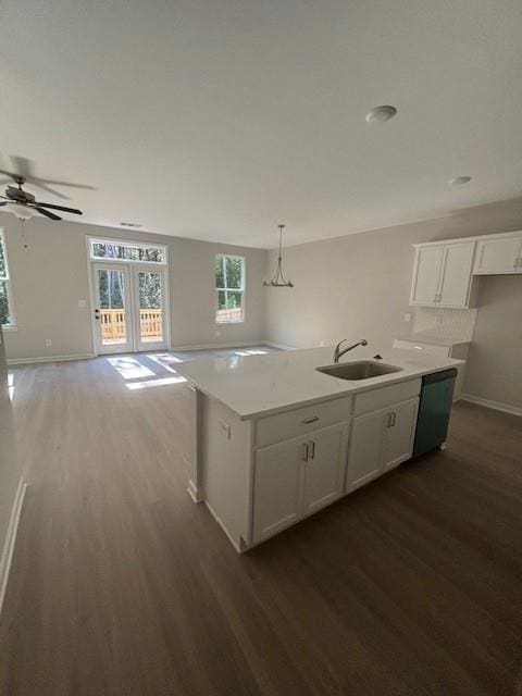 kitchen with black dishwasher, a center island with sink, white cabinetry, and hanging light fixtures