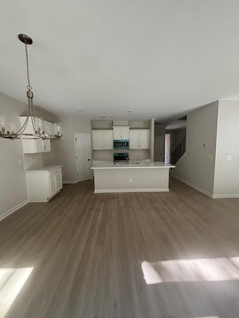 unfurnished living room featuring a chandelier, hardwood / wood-style floors, and sink