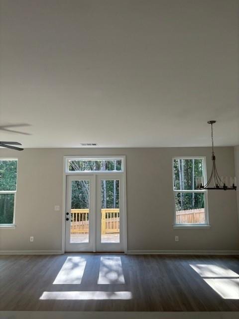 interior space featuring french doors, dark wood-type flooring, and ceiling fan with notable chandelier