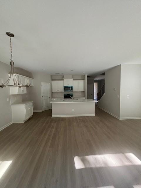 unfurnished living room featuring hardwood / wood-style floors and a notable chandelier