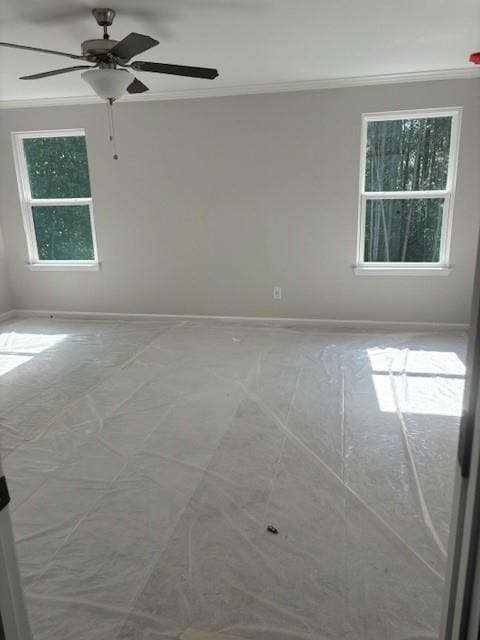 empty room with ceiling fan and ornamental molding