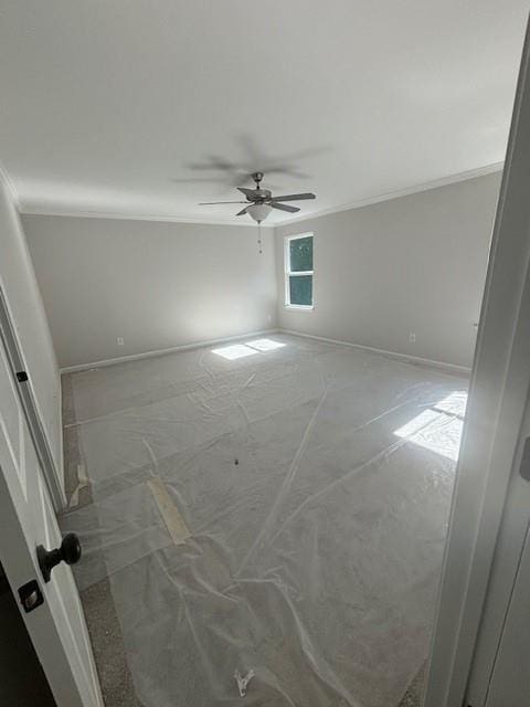 unfurnished room featuring ceiling fan and ornamental molding