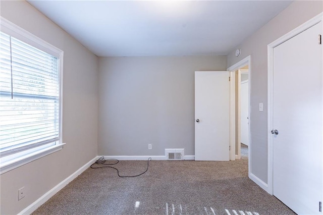 unfurnished bedroom with visible vents, baseboards, and carpet