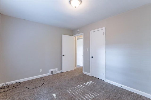 unfurnished room with visible vents, baseboards, and carpet flooring