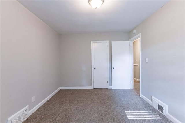 unfurnished room with baseboards, visible vents, and carpet floors