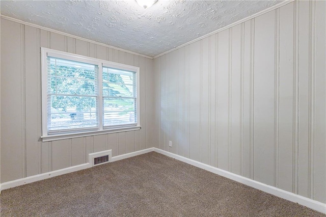 carpeted empty room featuring visible vents and a textured ceiling