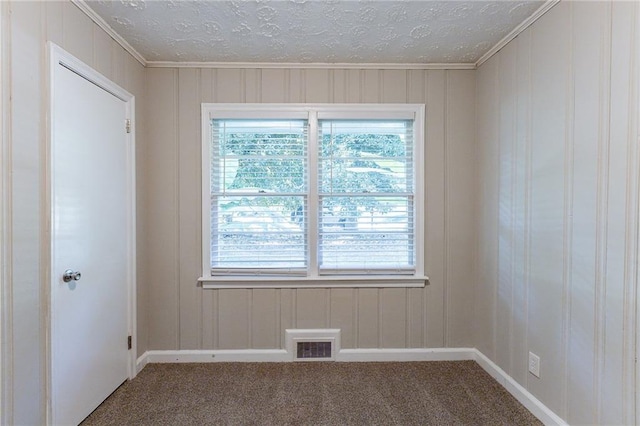 empty room with visible vents, carpet, and a textured ceiling