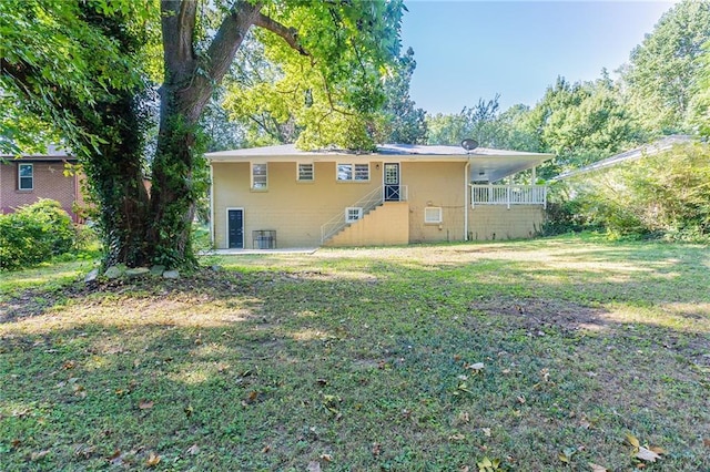 back of property featuring cooling unit and a lawn