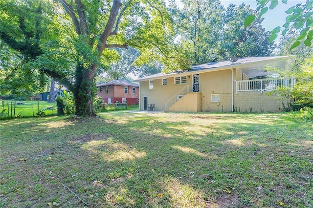 back of property with a yard and fence