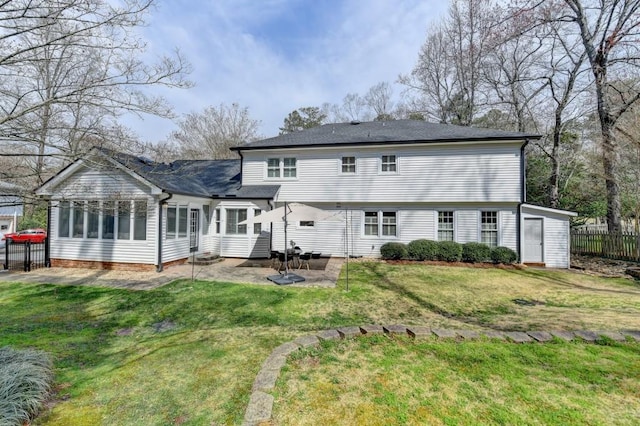 rear view of house featuring a patio, fence, a yard, and roof with shingles