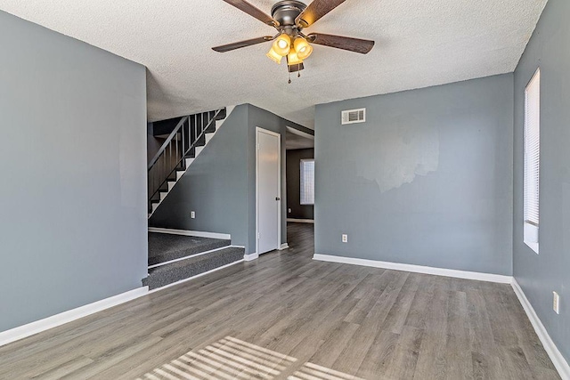 spare room with hardwood / wood-style flooring, ceiling fan, and a textured ceiling