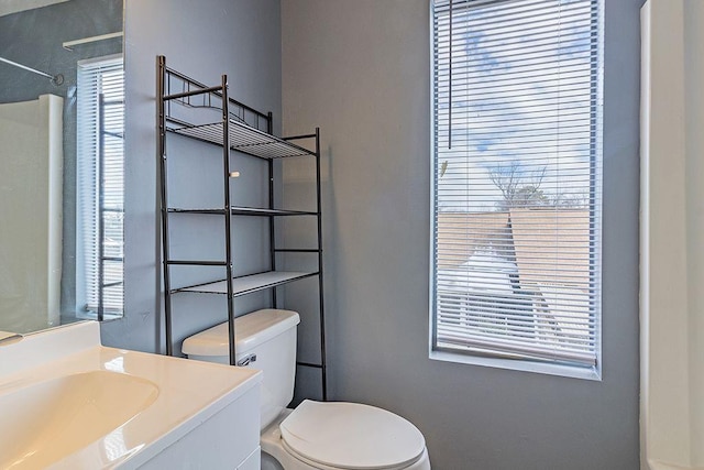 bathroom featuring vanity, a shower, and toilet