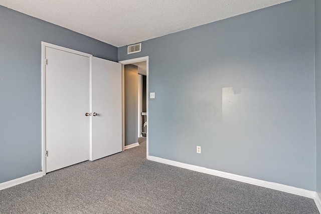 unfurnished bedroom featuring carpet and a textured ceiling