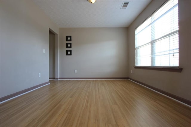 838 Roxholly Ln, Buford, GA 30518 - empty room with light wood-style floors, baseboards, and a textured ceiling