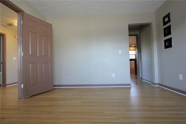 838 Roxholly Ln, Buford, GA 30518 - empty room with light wood-style floors, baseboards, and a textured ceiling