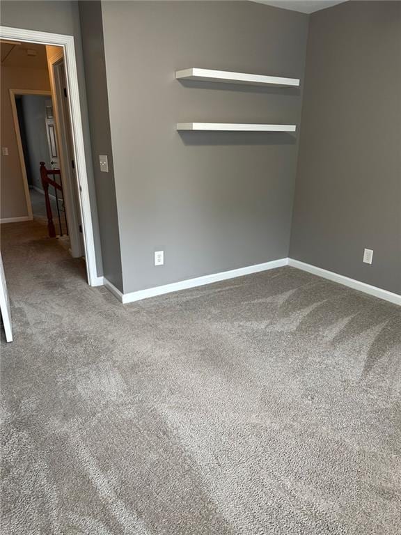 unfurnished room with carpet and baseboards