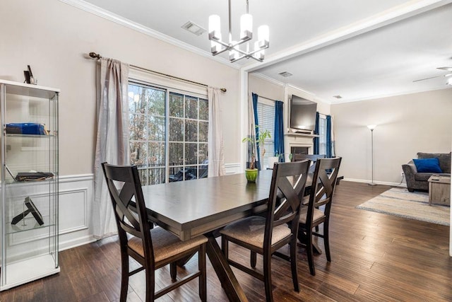 dining area with dark wood-type flooring, visible vents, and crown molding