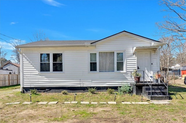 rear view of property with a yard and fence