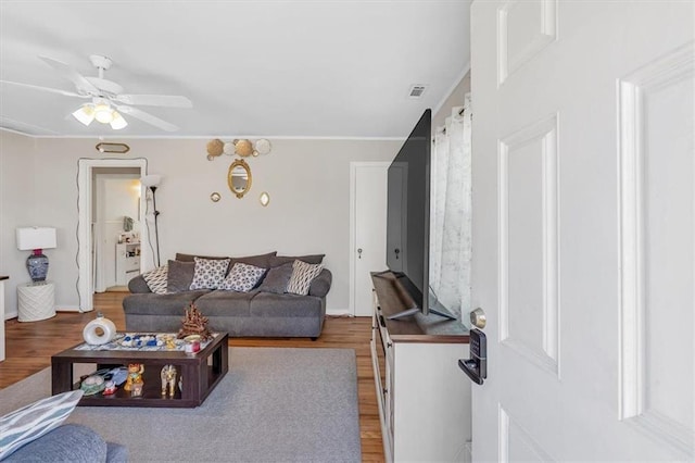 living area with ceiling fan, wood finished floors, and visible vents