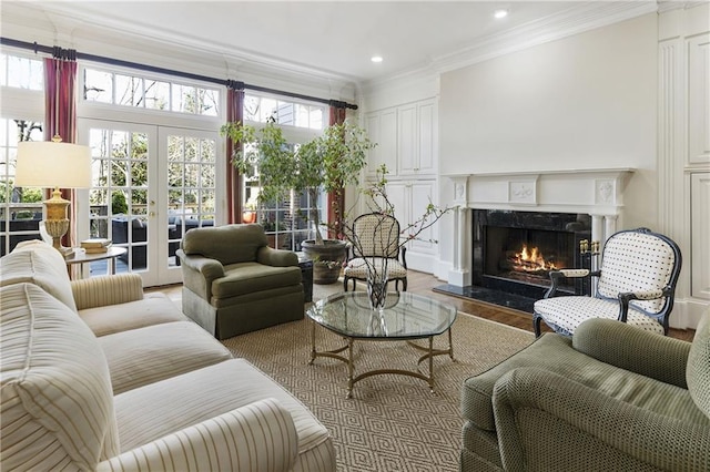 living area featuring crown molding, a premium fireplace, recessed lighting, french doors, and wood finished floors