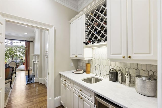 bar with crown molding, baseboards, dark wood-type flooring, decorative backsplash, and a sink