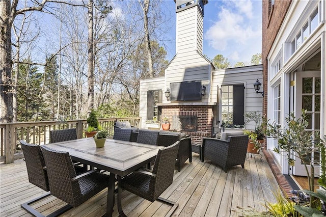 wooden deck featuring an outdoor living space with a fireplace and outdoor dining space