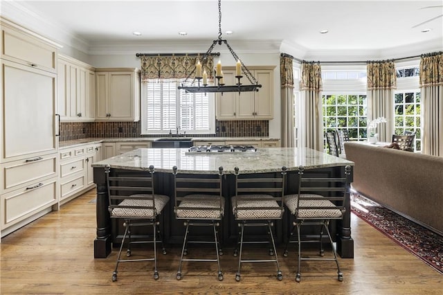 kitchen featuring a kitchen bar, a center island, crown molding, and stainless steel gas stovetop