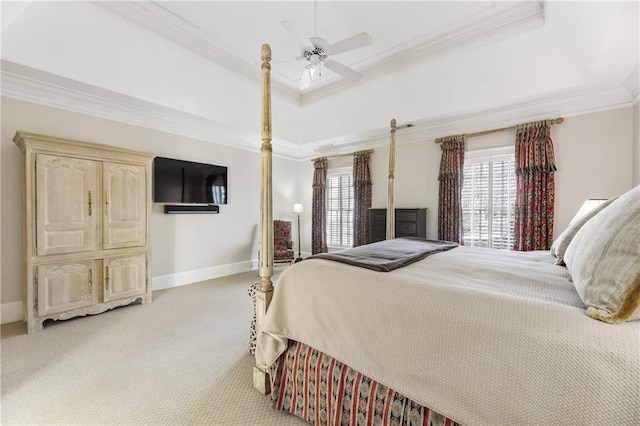 bedroom with light carpet, multiple windows, crown molding, and a tray ceiling