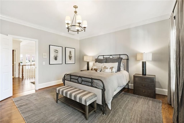 bedroom with baseboards, wood finished floors, and crown molding