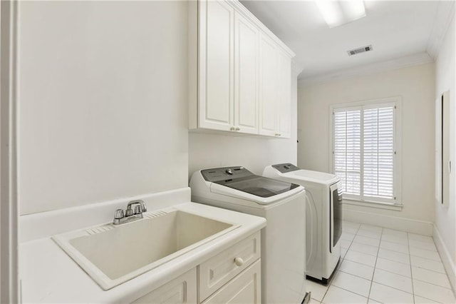 washroom featuring crown molding, washing machine and dryer, light tile patterned floors, cabinet space, and a sink