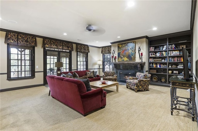 carpeted living area with ornamental molding, built in features, a glass covered fireplace, recessed lighting, and baseboards