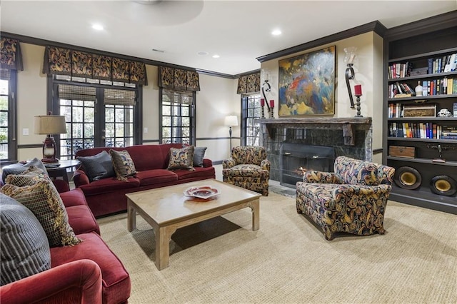 living area with built in features, recessed lighting, french doors, a lit fireplace, and crown molding