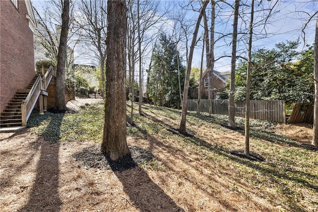 view of yard featuring stairs and fence