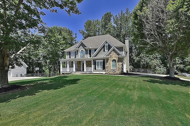 view of front of home with covered porch and a front lawn