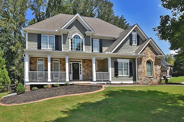 craftsman house featuring covered porch and a front yard