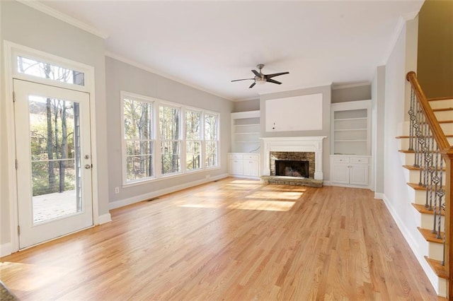 unfurnished living room featuring a fireplace, light wood-type flooring, a wealth of natural light, and baseboards