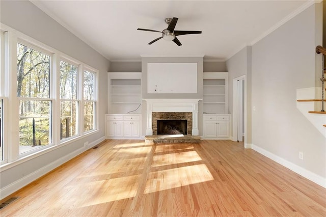 unfurnished living room featuring visible vents, light wood-style flooring, a fireplace, baseboards, and stairs