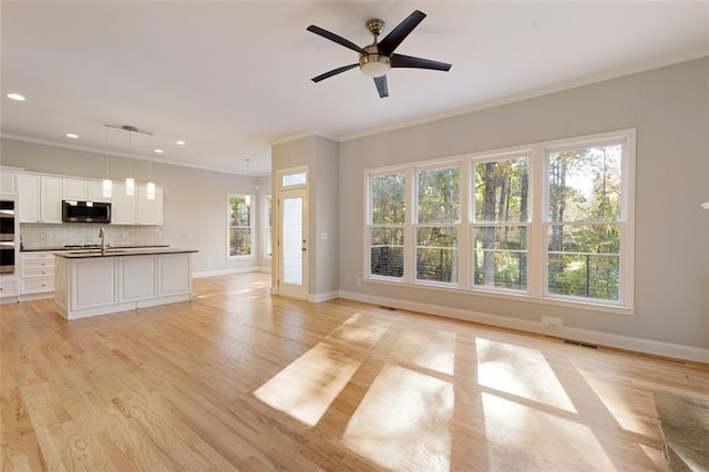 unfurnished living room featuring light wood-type flooring, baseboards, visible vents, and ornamental molding