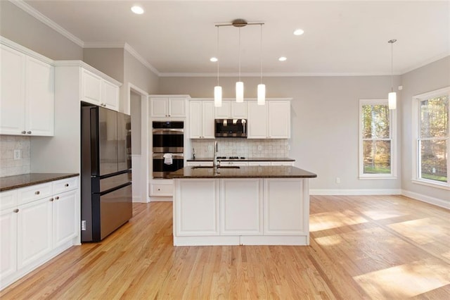 kitchen with stainless steel appliances, light wood-style flooring, crown molding, and white cabinetry