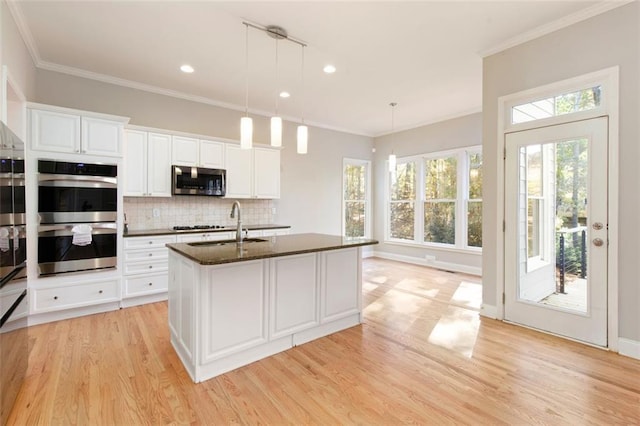 kitchen with backsplash, appliances with stainless steel finishes, light wood-style floors, and ornamental molding