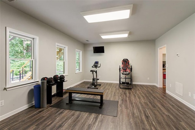 exercise room featuring visible vents, baseboards, and wood finished floors