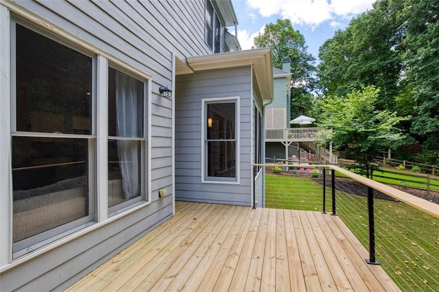 wooden deck featuring a lawn