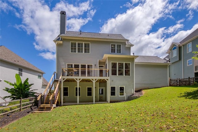 rear view of house with stairway, a fenced backyard, a lawn, and a wooden deck