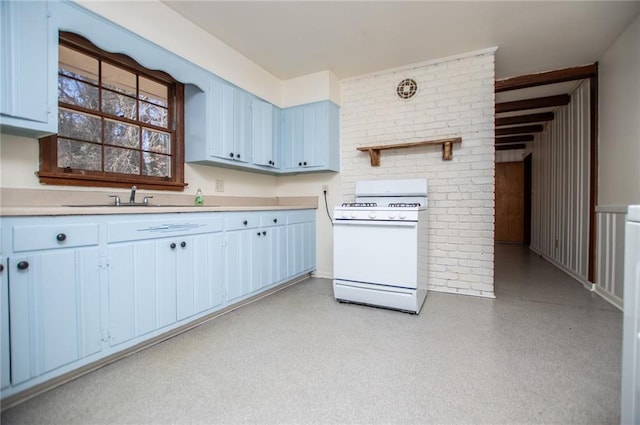 kitchen with blue cabinets, sink, and white range with gas stovetop