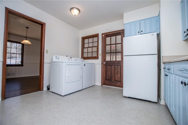 clothes washing area featuring cabinets and washing machine and clothes dryer