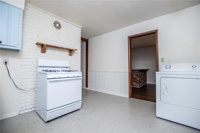 clothes washing area featuring brick wall and washer / dryer