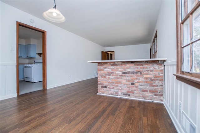 bar with hanging light fixtures, dark wood-type flooring, and white range with gas stovetop