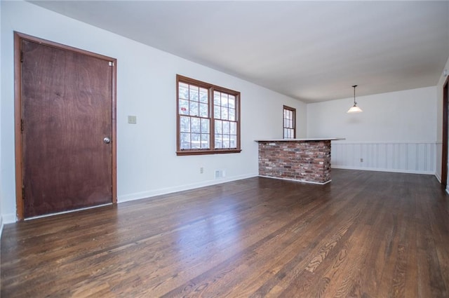 unfurnished living room with dark wood-type flooring and indoor bar