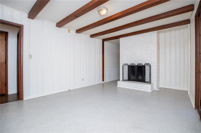 unfurnished living room with a brick fireplace and beam ceiling